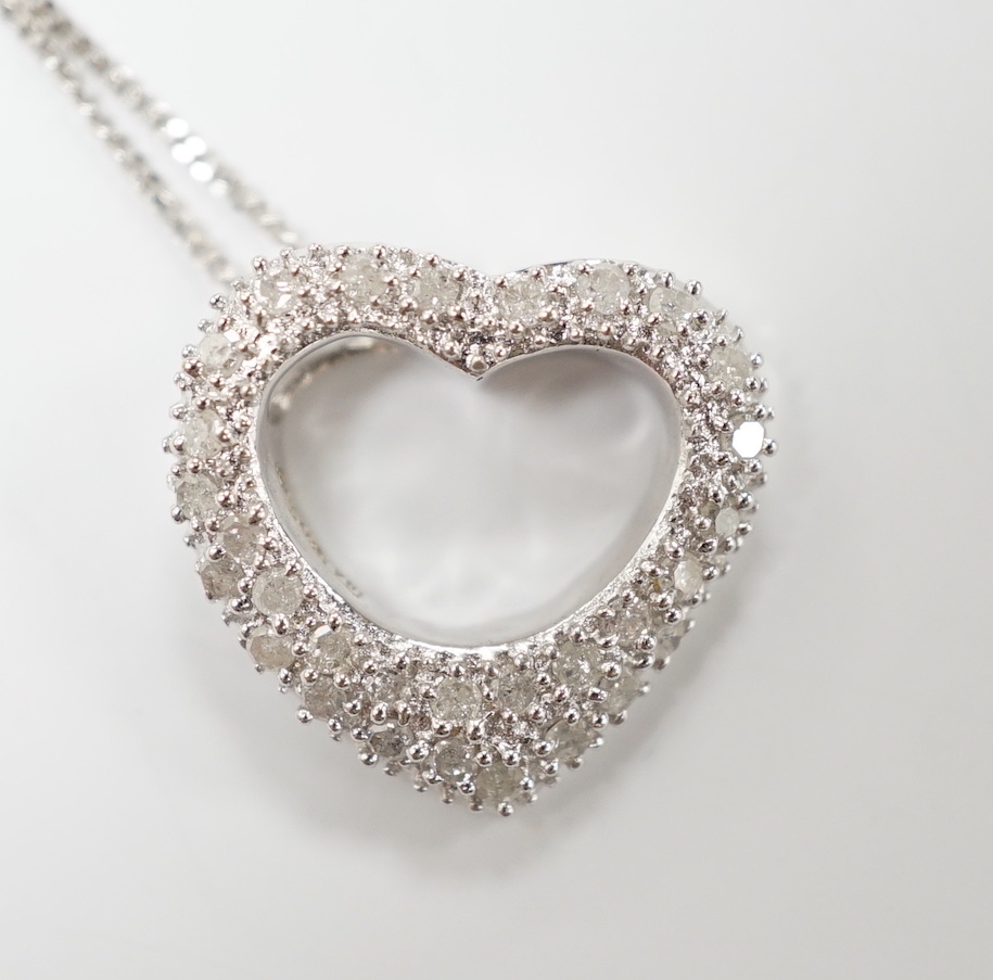 A modern 375 white metal and diamond chip set heart shaped pendant on chain, overall 42cm, gross weight 2.4 grams.